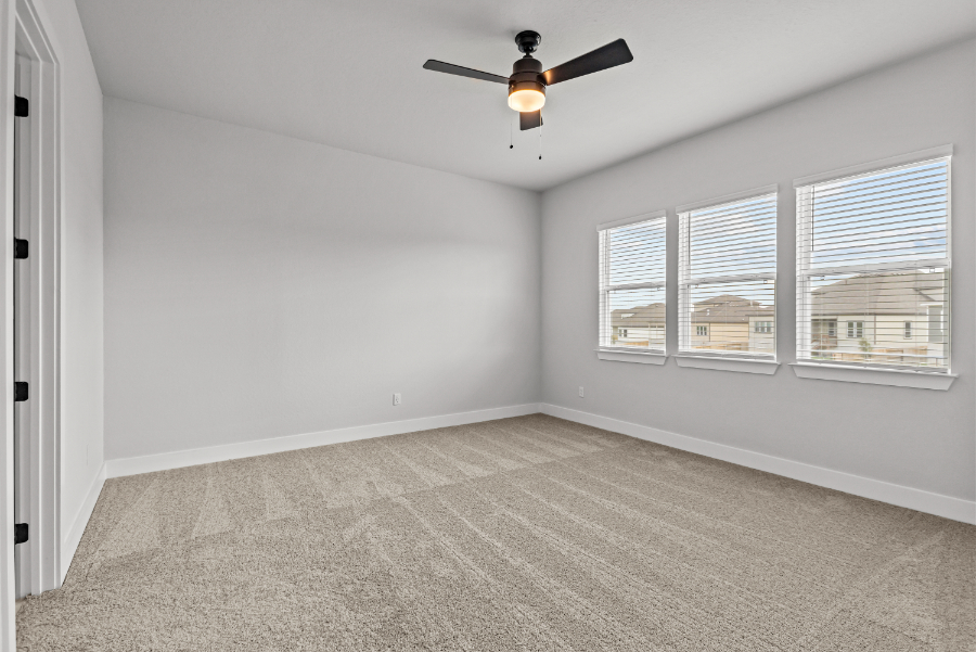 A room with a ceiling fan and a window.