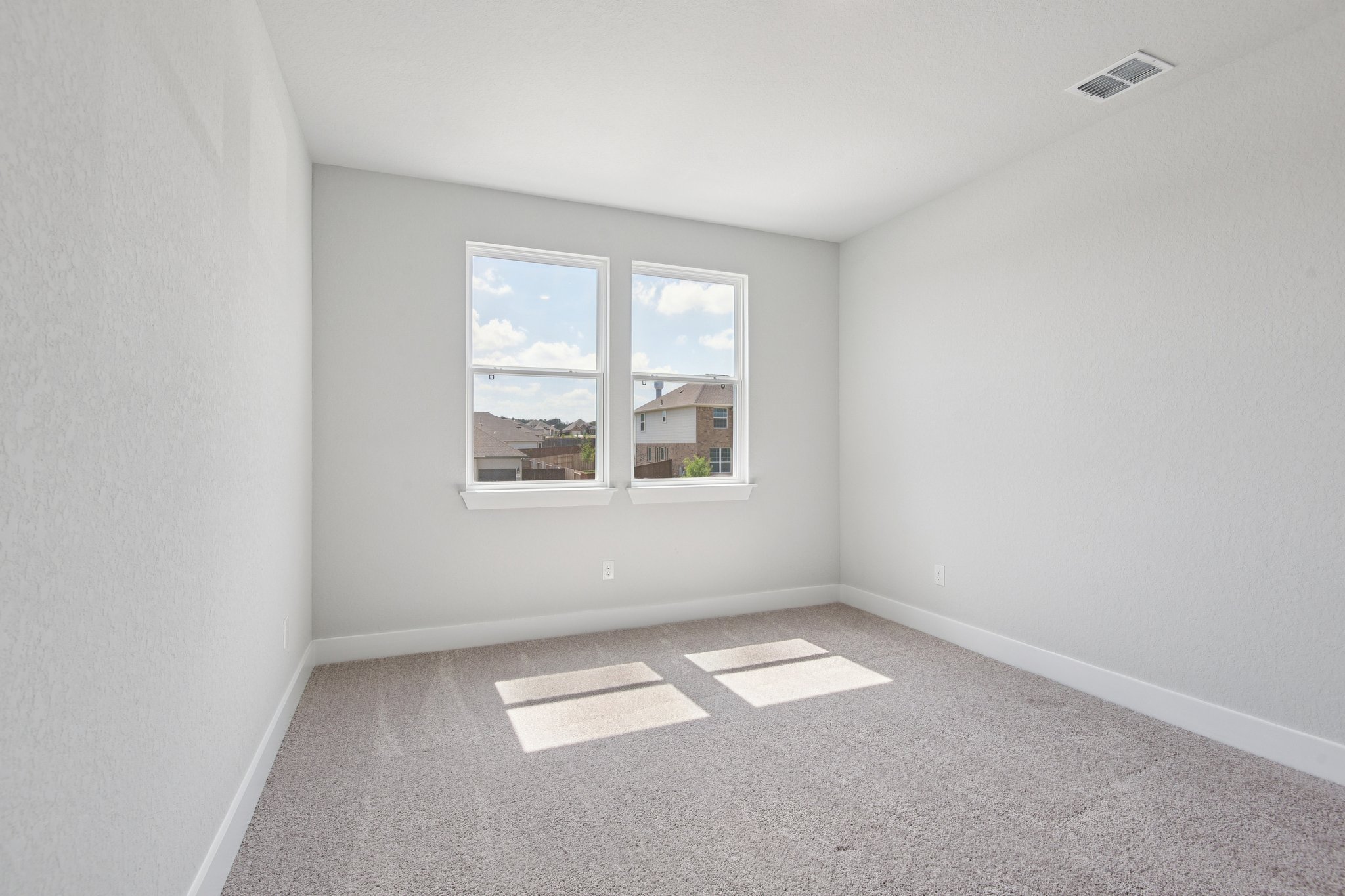 A room with a window and a rug.