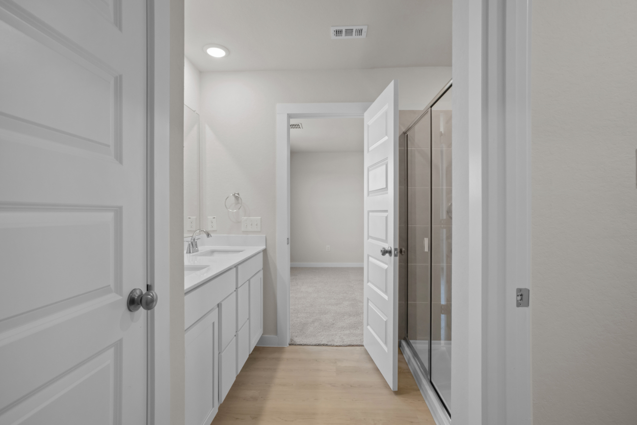 A bathroom with white cabinets.