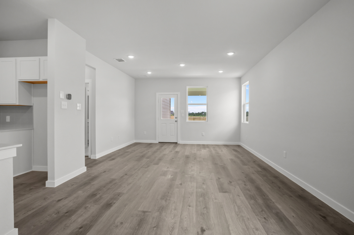 A room with white walls and wood floors.