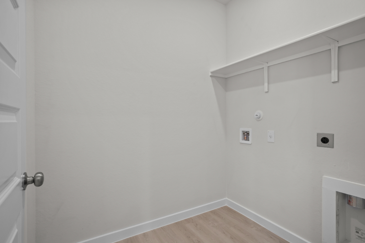 A white room with a wood floor and white walls.