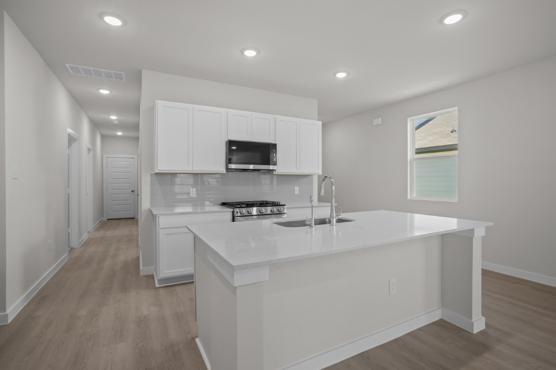 A kitchen with white cabinets.