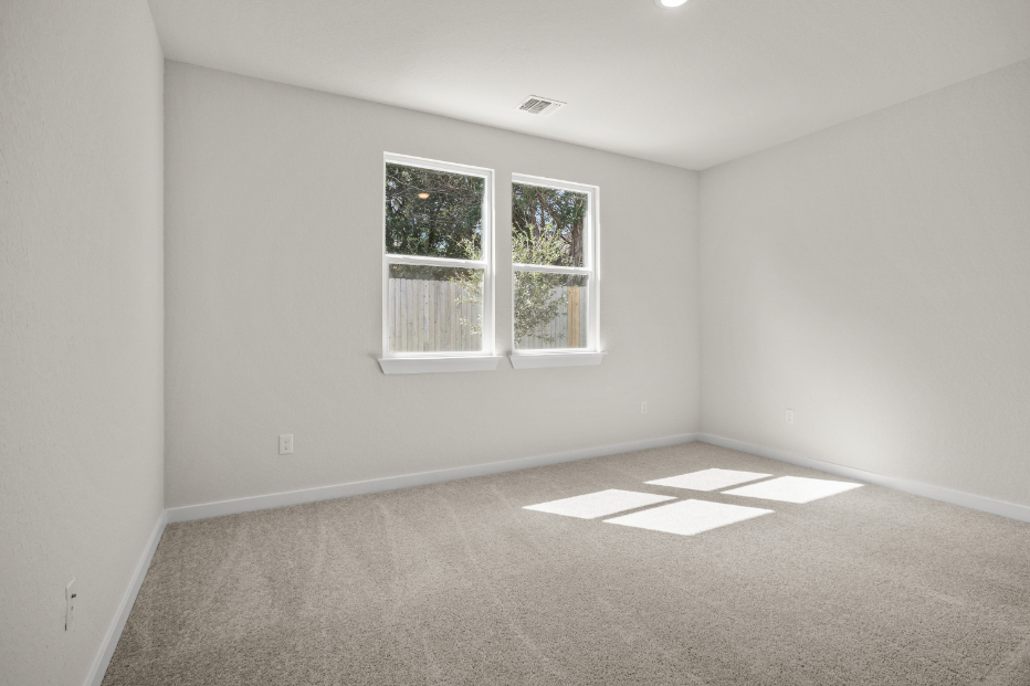 A room with a window and a rug.