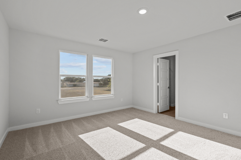 A room with a window and a rug.