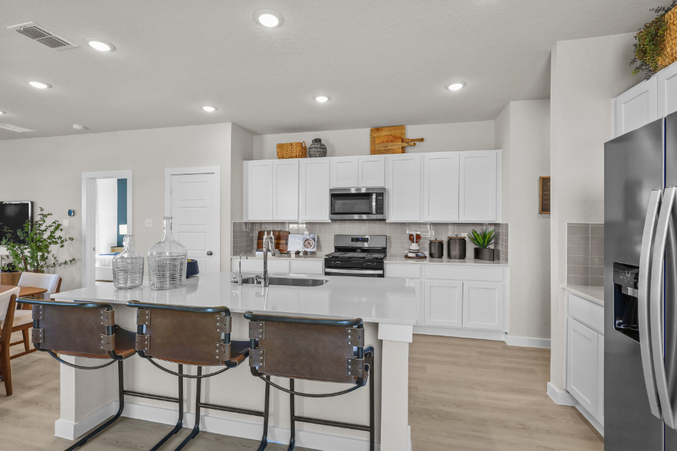 A kitchen with white cabinets.
