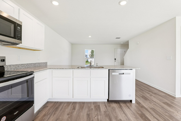 A kitchen with white cabinets.