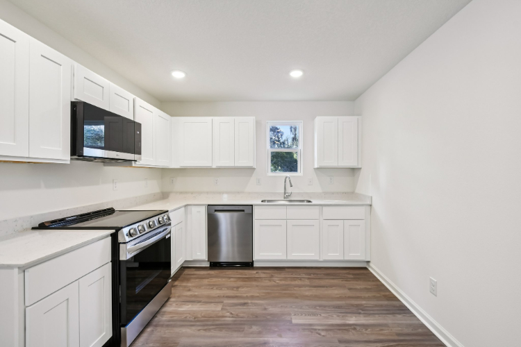 A kitchen with white cabinets.