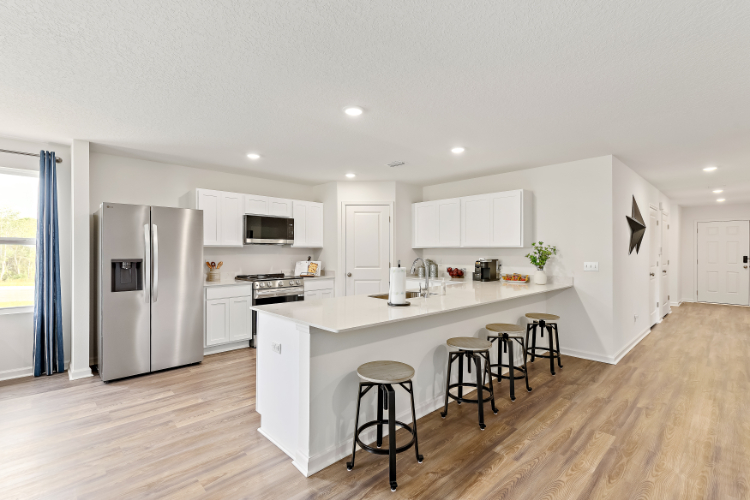 A kitchen with white cabinets.