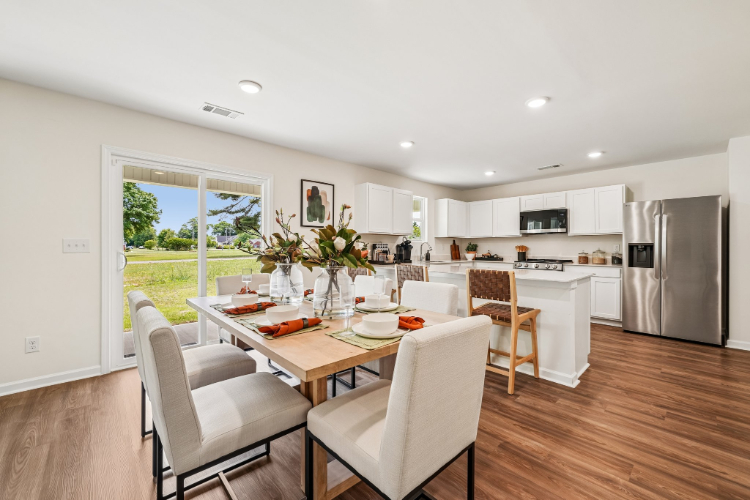 A kitchen with a dining table and chairs.