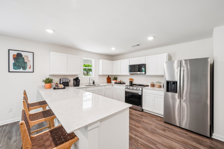 A kitchen with white cabinets.