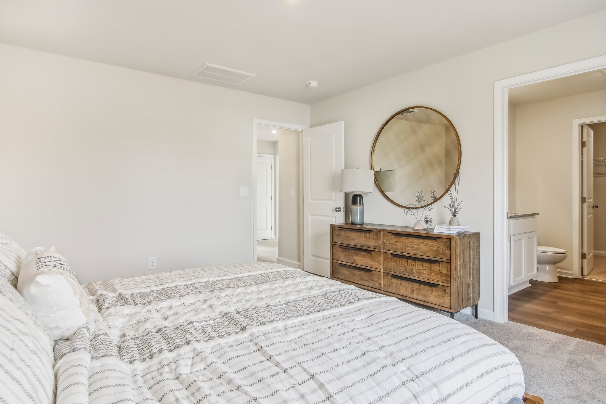 A bedroom with a large mirror.