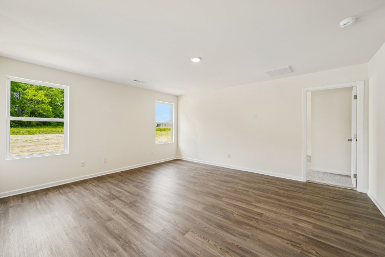 A room with a wood floor and a wood floor with a door and a window with a tree.