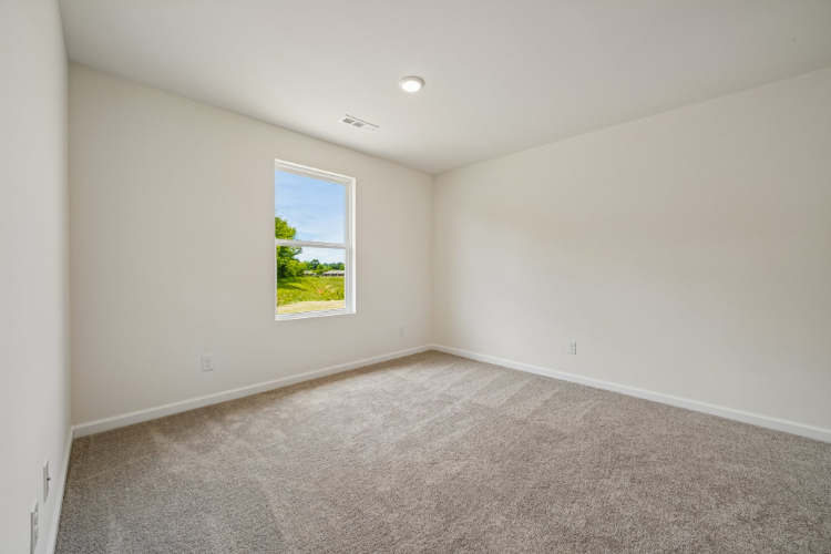 A room with a window and carpet.
