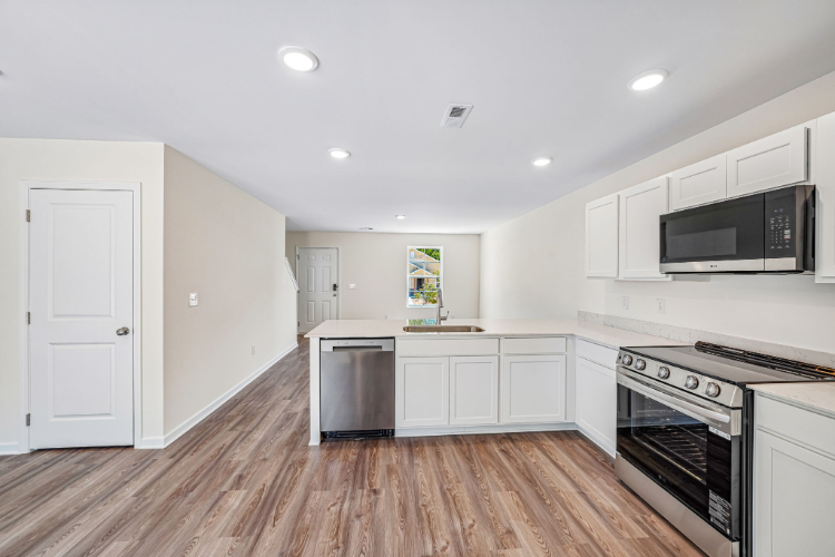 A kitchen with white cabinets.