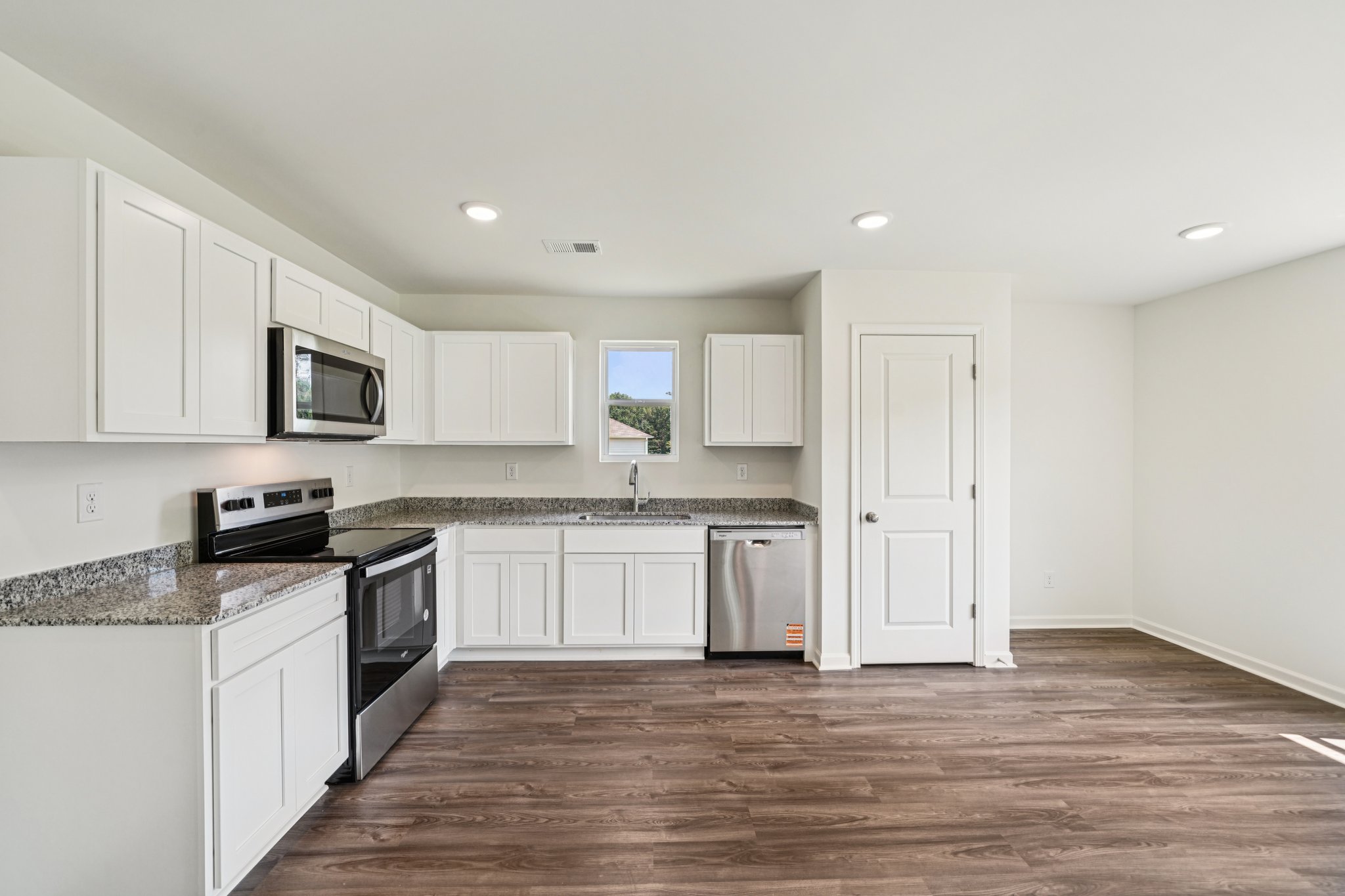 A kitchen with white cabinets.